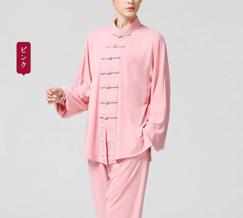 ピンク色の花柄刺繍長袖練習服を着る女性