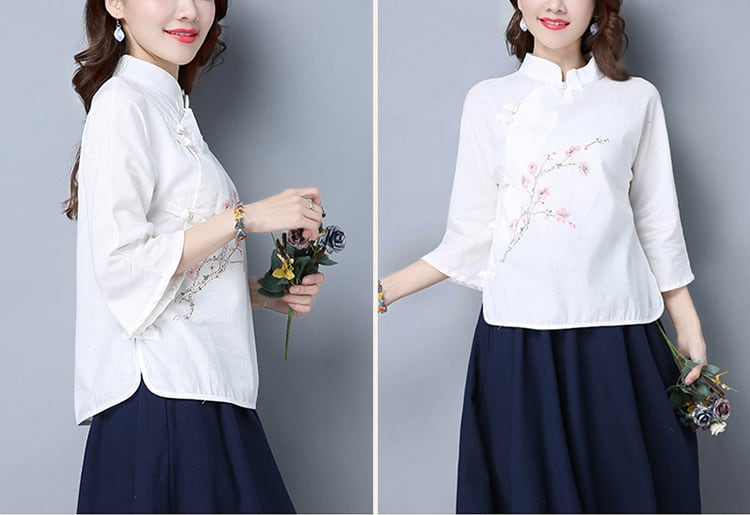 白の太極拳ブラウスと紺色のスカートを着る女性